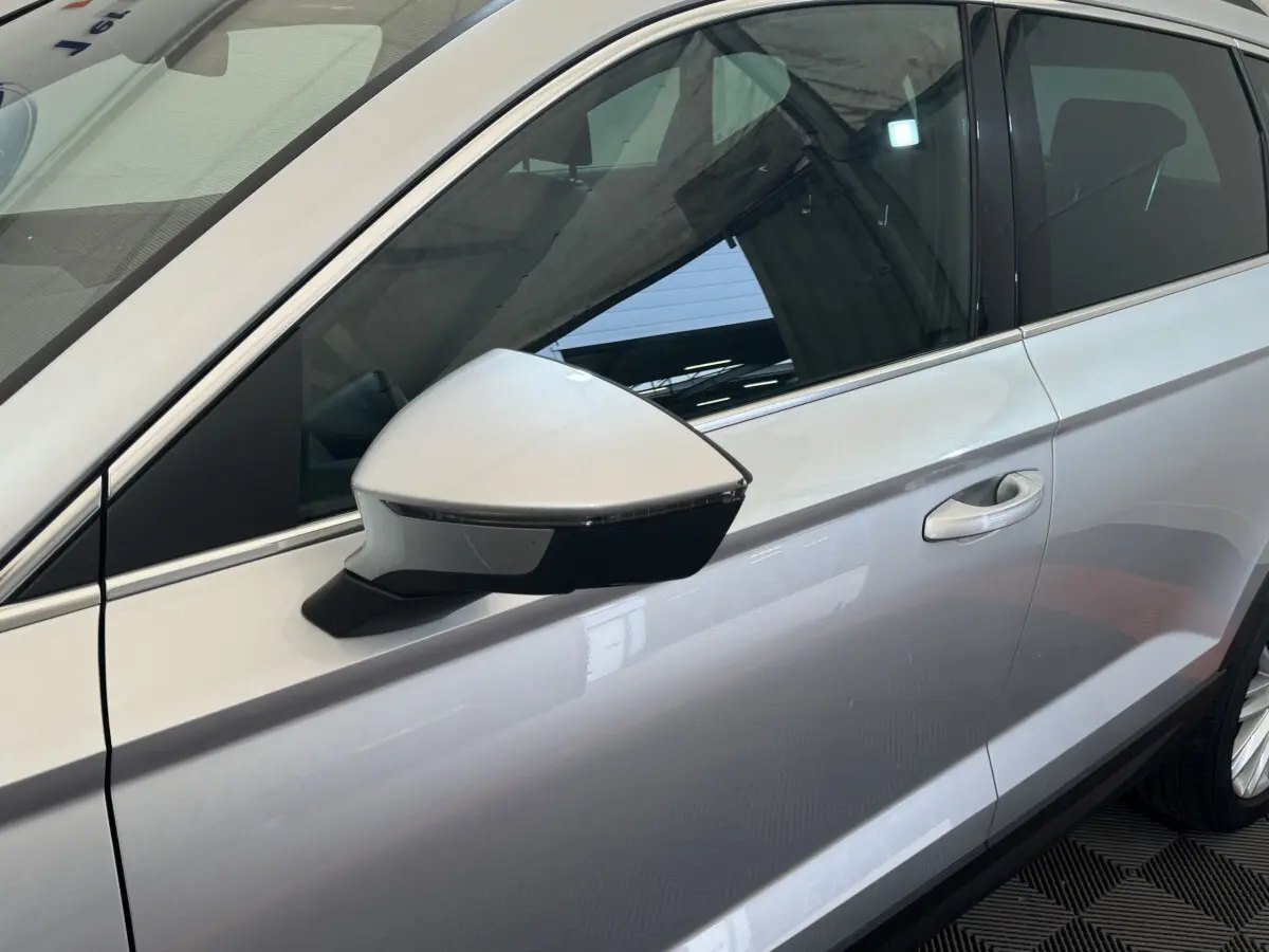 Détail du rétroviseur côté gauche gris clair du SEAT Ateca 2019 avec poignée de porte visible en arrière-plan.