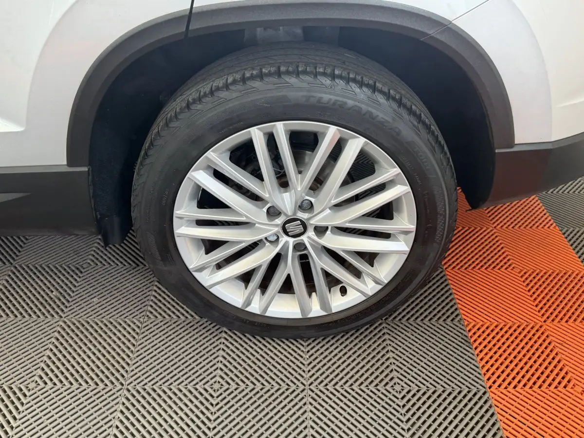 Gros plan sur la roue avant droite du SEAT Ateca gris clair, mettant en valeur la jante alliage multi-branches.