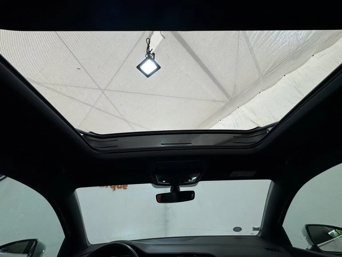 Toit ouvrant panoramique ouvert vu de l'intérieur avant du SEAT Ateca gris clair 2019 avec rétroviseurs visibles