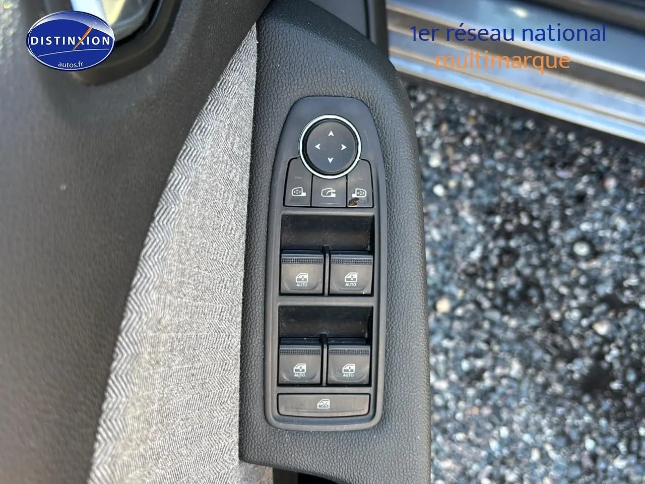 Commandes des vitres électriques et rétroviseurs sur la porte côté conducteur d'une Renault Clio V gris pizarra.