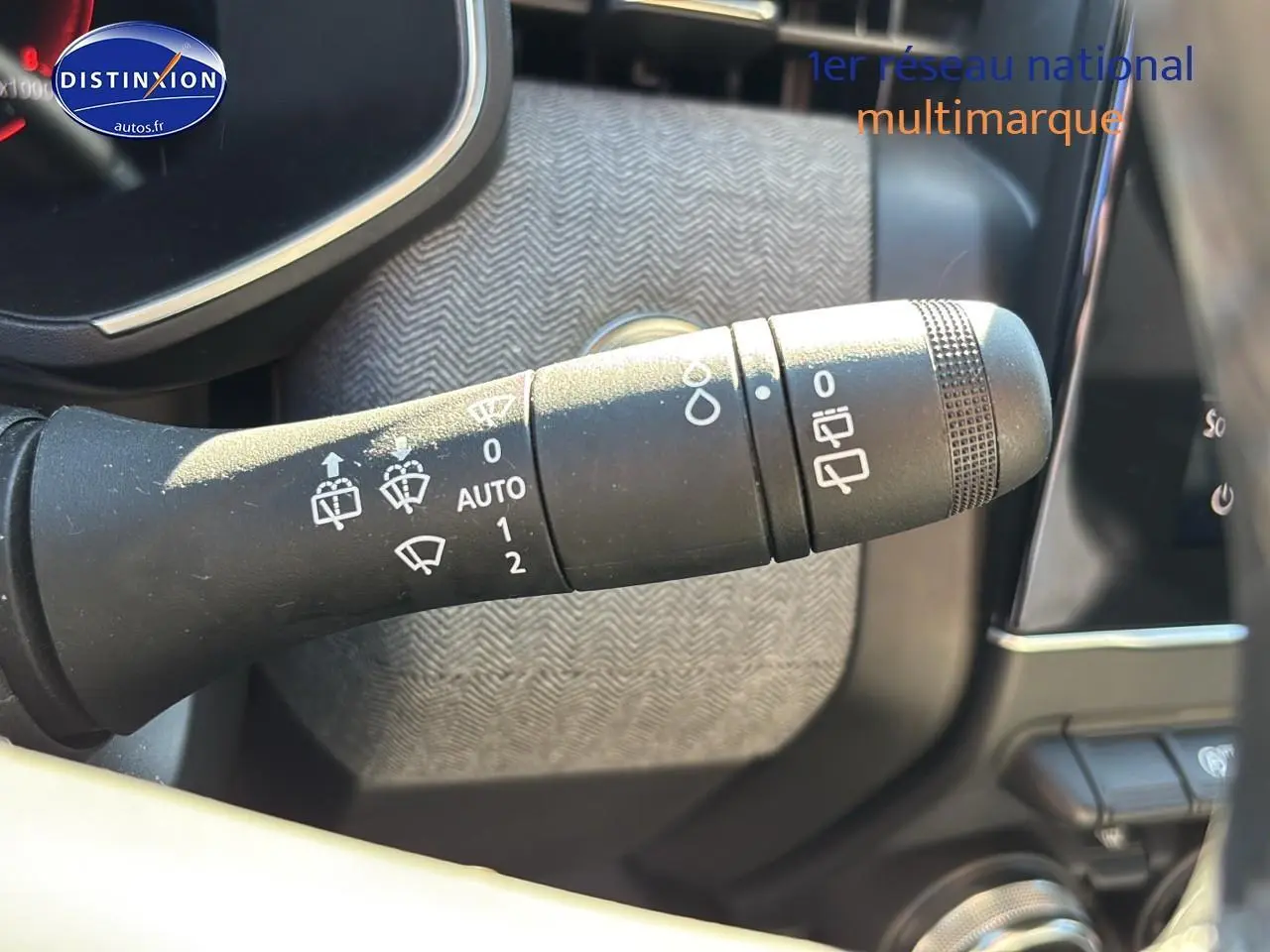 Gros plan sur la commande des essuie-glaces dans l’habitacle de la Renault Clio V gris pizarra 2024.