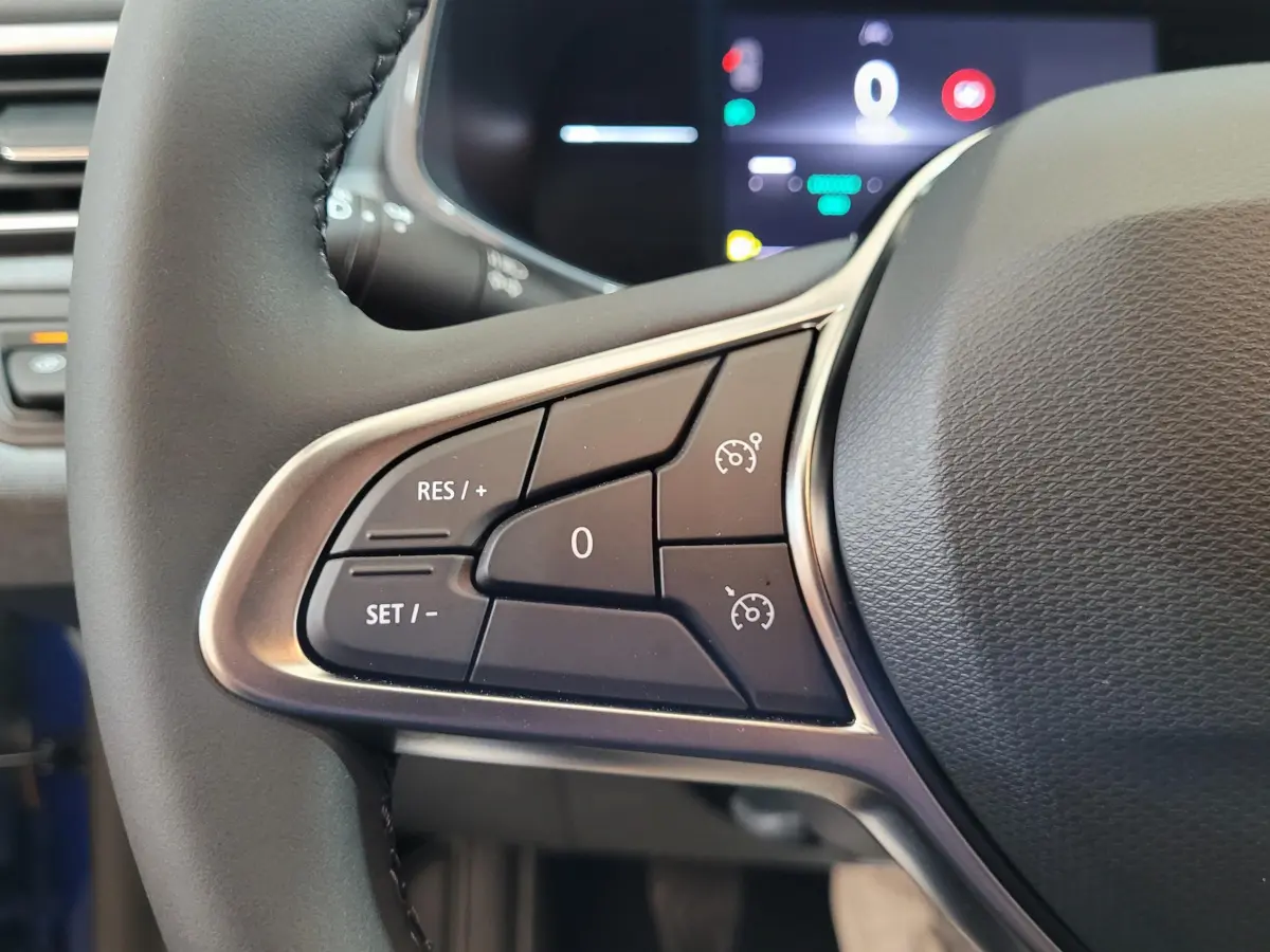 Détail du volant côté gauche de la Renault Clio bleu 2025 avec commandes du régulateur de vitesse et affichage digital.