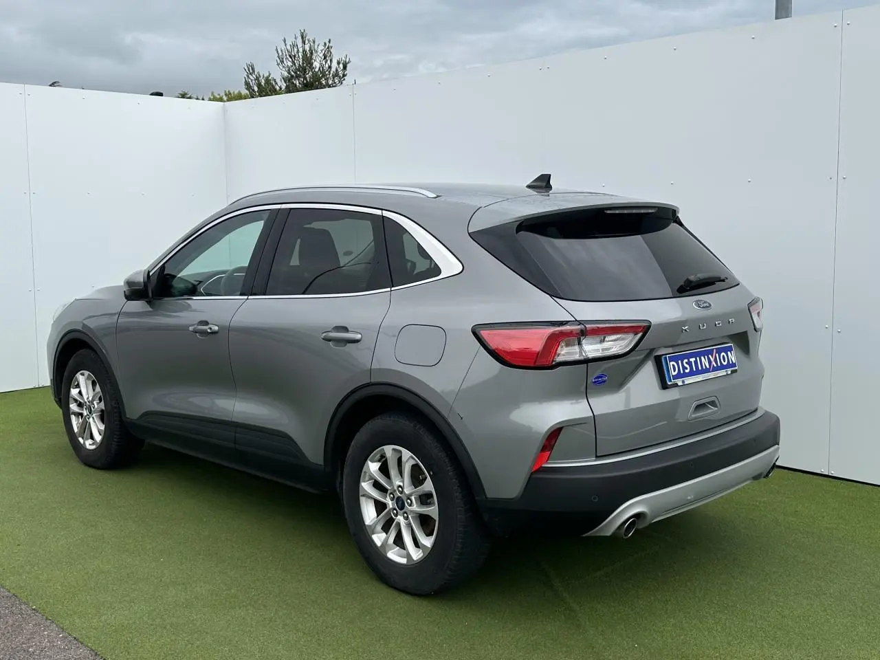 Ford Kuga gris solaire vue 3/4 arrière droit avec barres de toit aluminium et vitres arrière surteintées