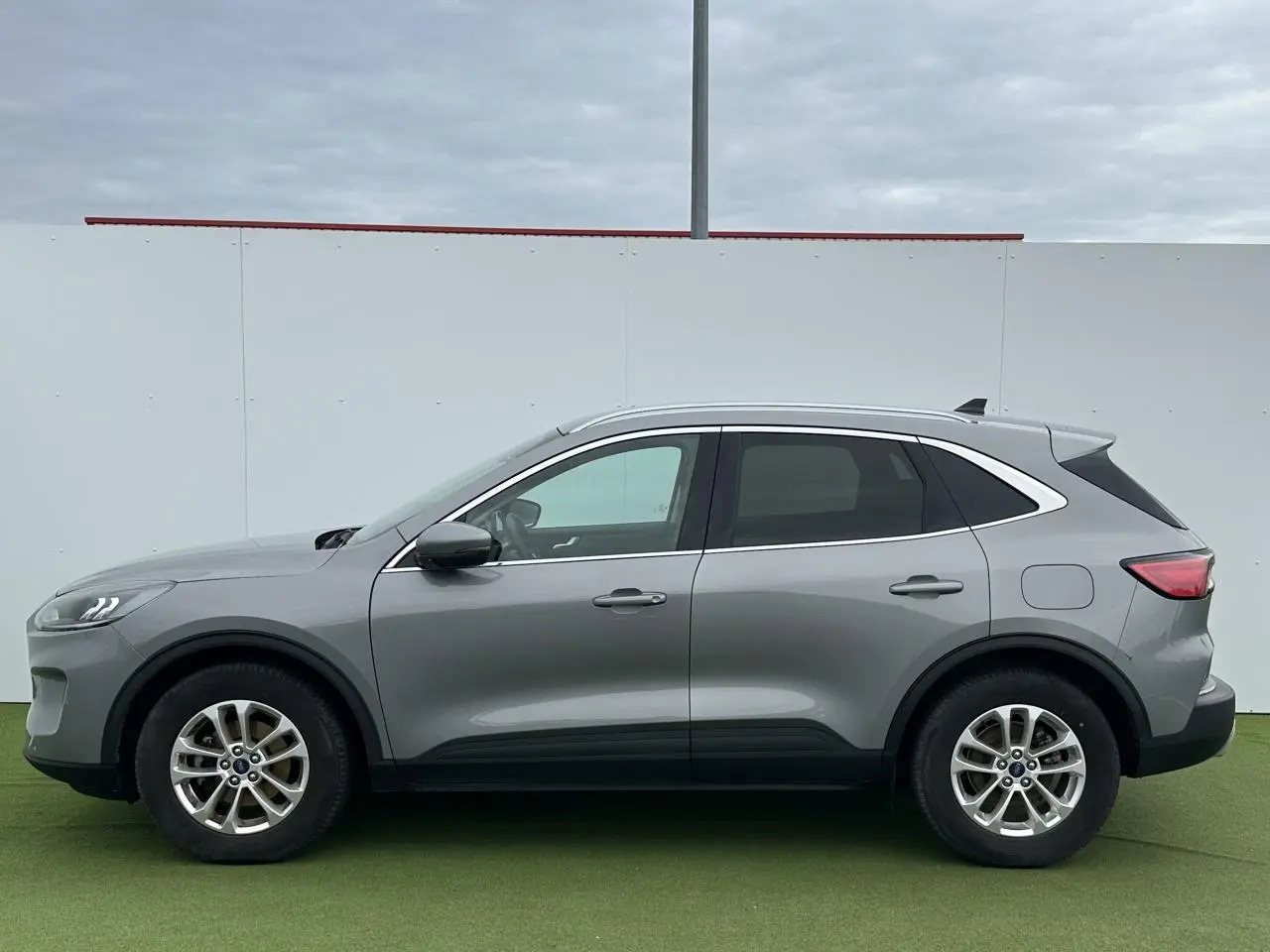 Profil côté gauche du Ford Kuga III gris solaire 2020 avec jantes alliage 17 pouces et vitres arrière surteintées.