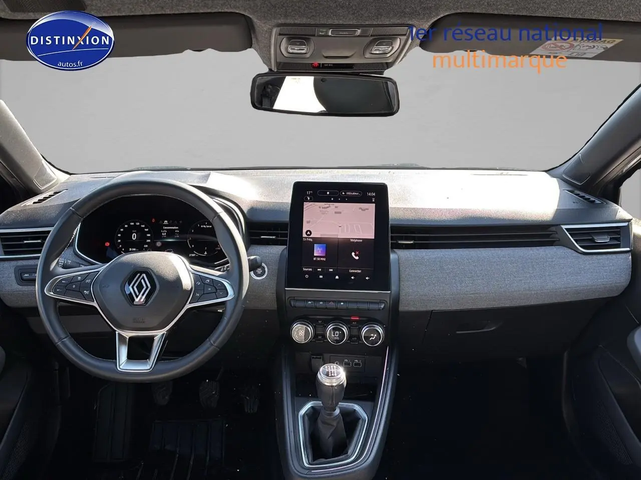 Intérieur de Renault Clio V gris pizarra, vue frontale sur tableau de bord avec écran tactile vertical et volant multifonction.