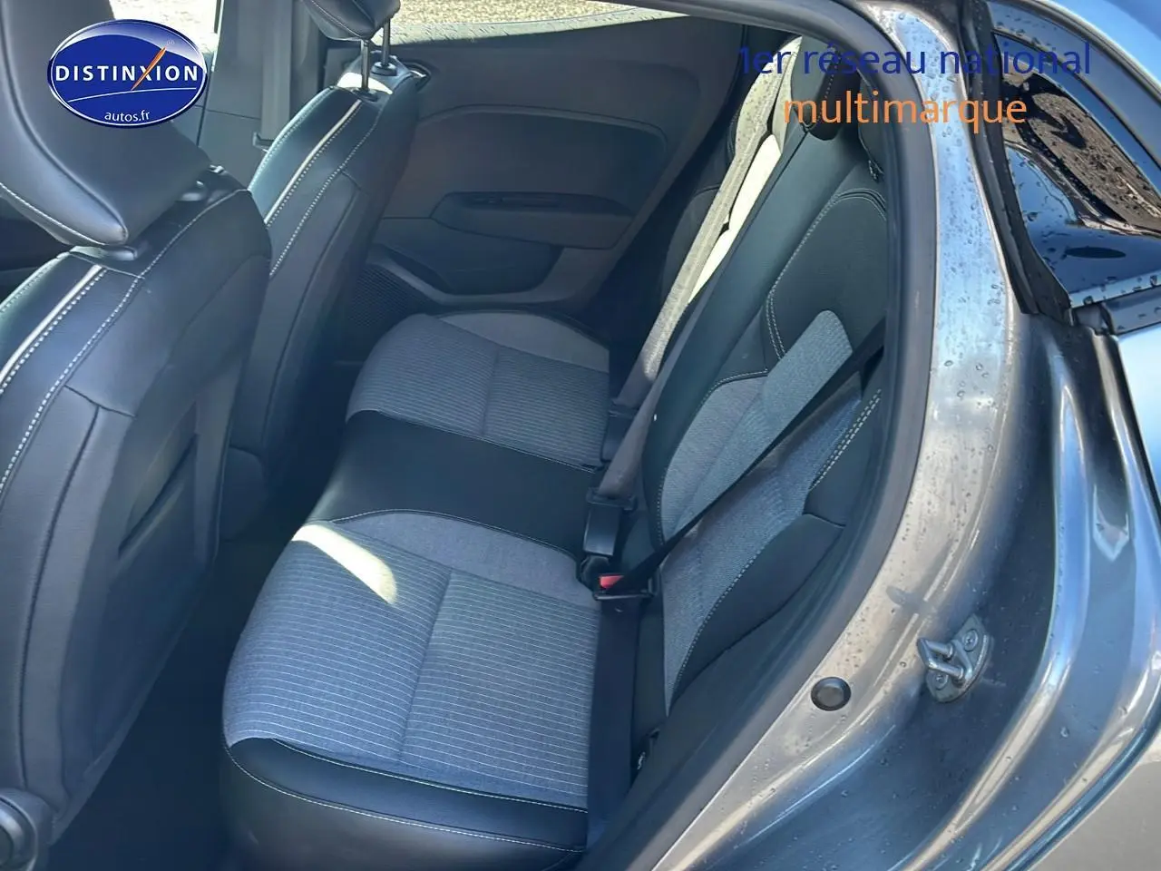 Vue côté droit de l'intérieur arrière de la Renault Clio V gris pizarra avec sellerie textile gris et noir à surpiqûres cuivre.