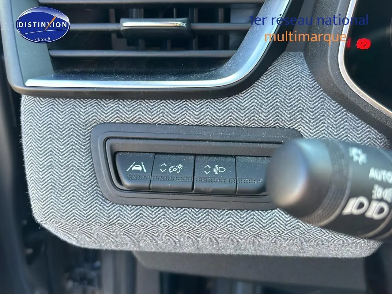 Détail des commandes d'assistance sur tableau de bord avec habillage textile gris à chevrons Renault Clio V 2024