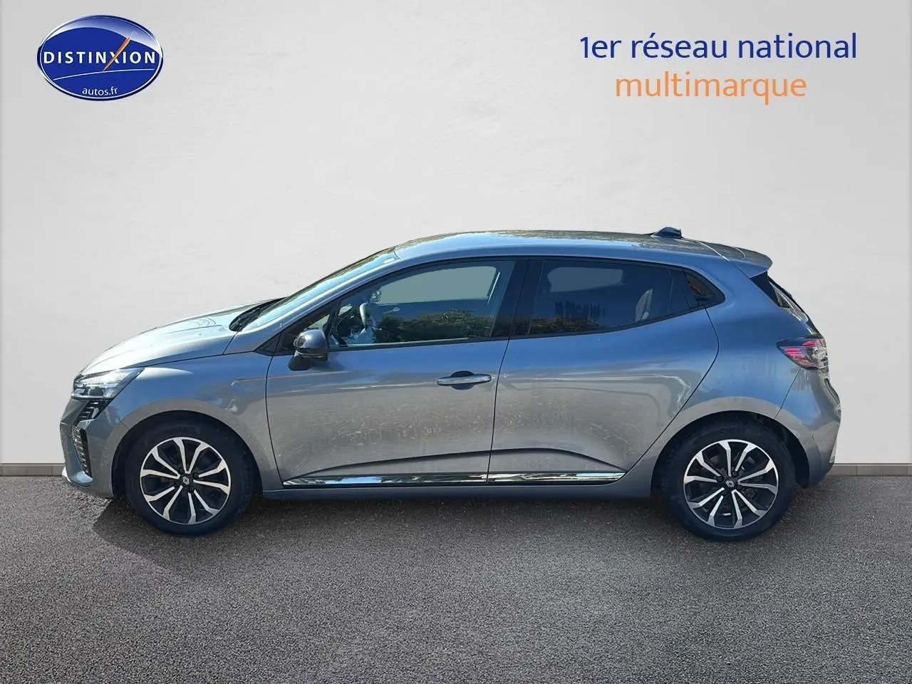 Profil droit de la Renault Clio V gris pizarra 2024 avec jantes alliage noires et détails chromés sur les portes.