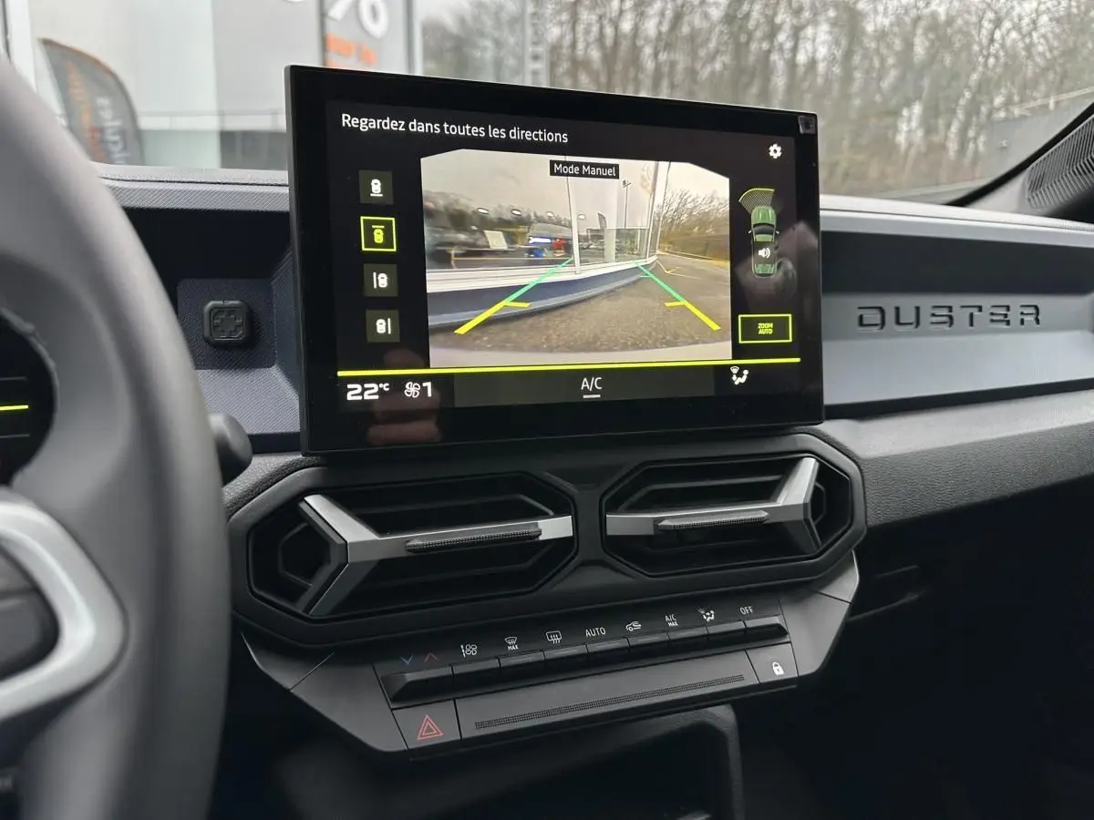 Vue intérieure du tableau de bord du Dacia Duster noir 2025, écran central affichant la caméra de recul.