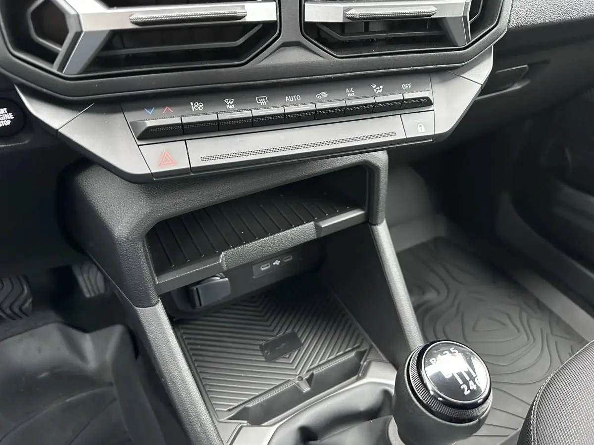 Gros plan sur la console centrale noire du Dacia Duster 2025 avec boîte manuelle et prises USB type C visibles.