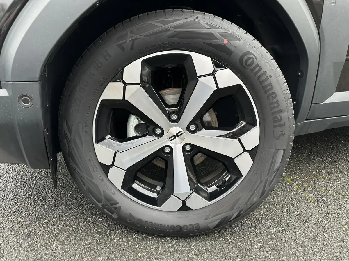 Gros plan sur la jante alliage diamantée 18” du Dacia Duster noir, avec pneu Continental visible côté gauche.