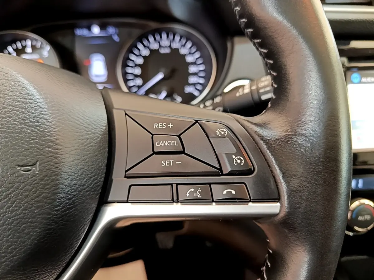Gros plan sur le volant cuir noir du Nissan Qashqai 2019, avec commandes de régulateur de vitesse à droite.