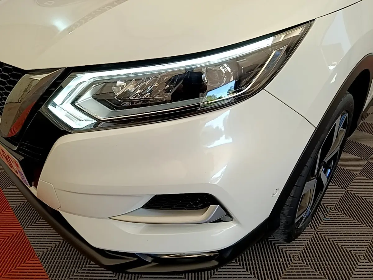 Gros plan sur l'avant droit blanc du Nissan Qashqai 2019 avec phares LED et jante alliage noire.
