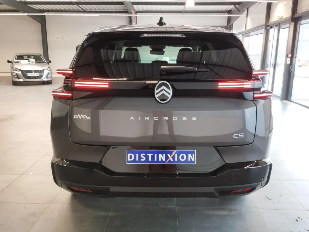 Vue arrière d'un Citroën C5 Aircross gris platine avec feux arrière LED horizontaux et logo central distinctif.