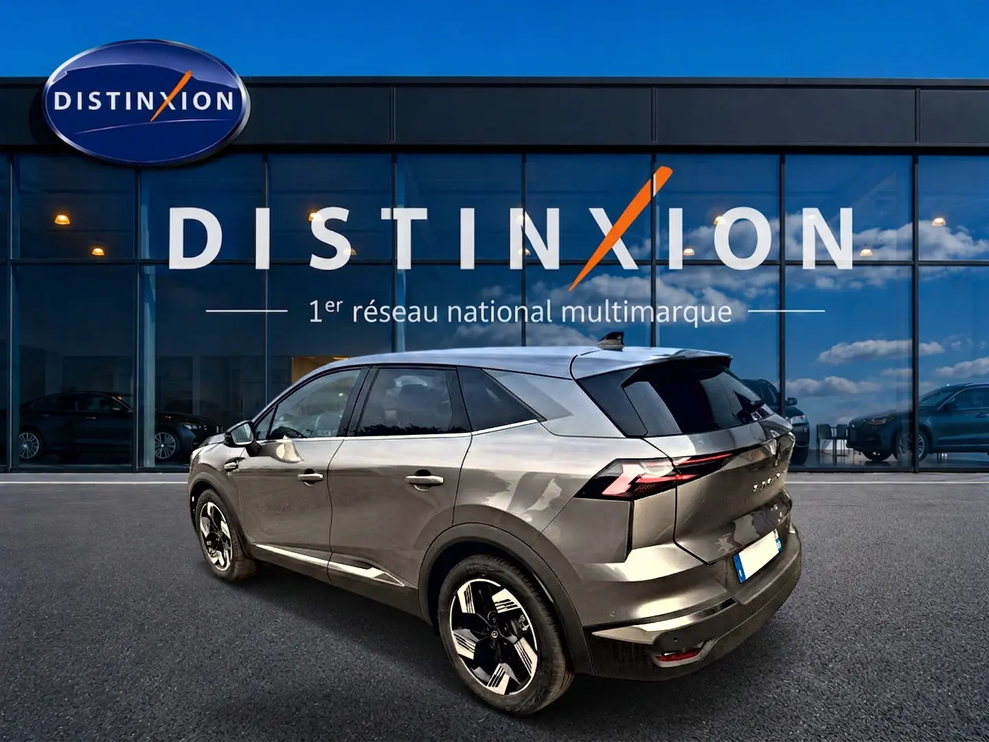 Renault Symbioz gris cassiopée en 3/4 arrière droit, avec feux arrière LED et jantes alu distinctives.