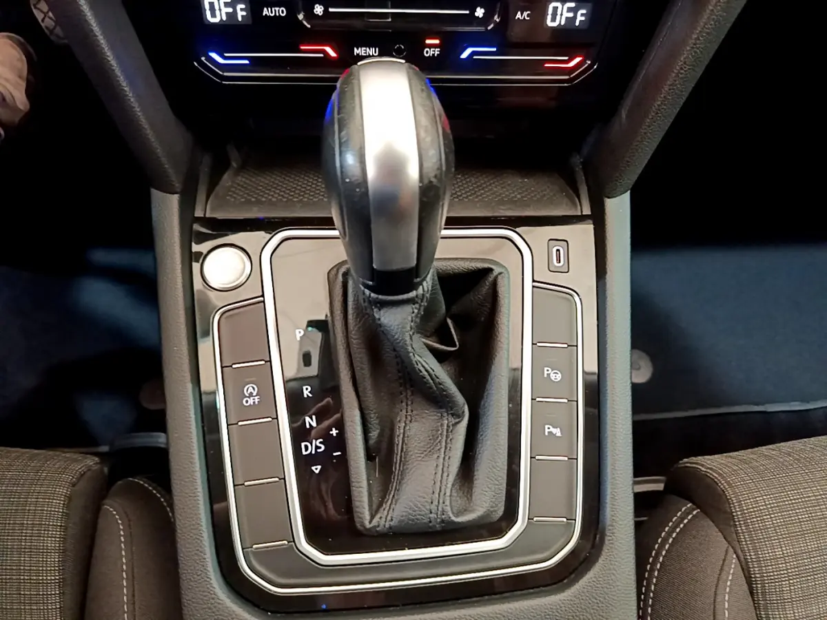 Le levier de vitesses automatique noir et argenté de la Volkswagen Passat gris foncé, vu de dessus au centre de la console.