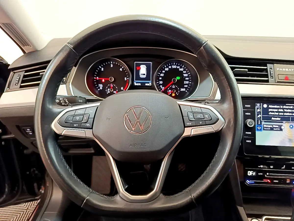 Vue rapprochée du volant cuir noir et du tableau de bord digital de la Volkswagen Passat 2.0 TDI 2021.