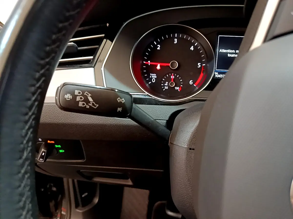 Vue rapprochée du tableau de bord et du commodo gauche de la Volkswagen Passat gris foncé 2021, affichage digital visible.