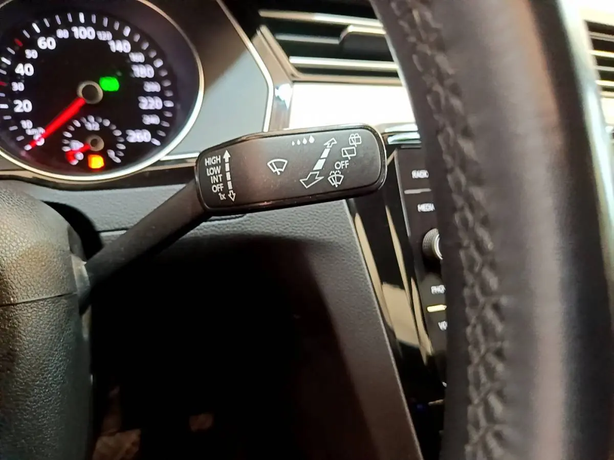 Gros plan sur la manette d’essuie-glace côté gauche du tableau de bord d’une Volkswagen Passat gris foncé 2021.