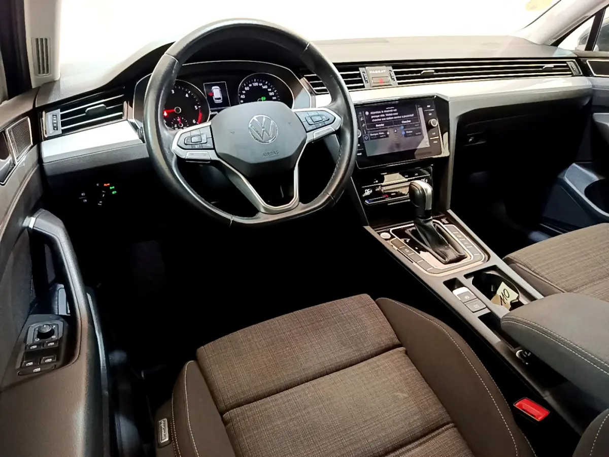 Vue intérieure avant droite du tableau de bord et volant cuir de la Volkswagen Passat 2.0 TDI gris foncé avec écran tactile central.