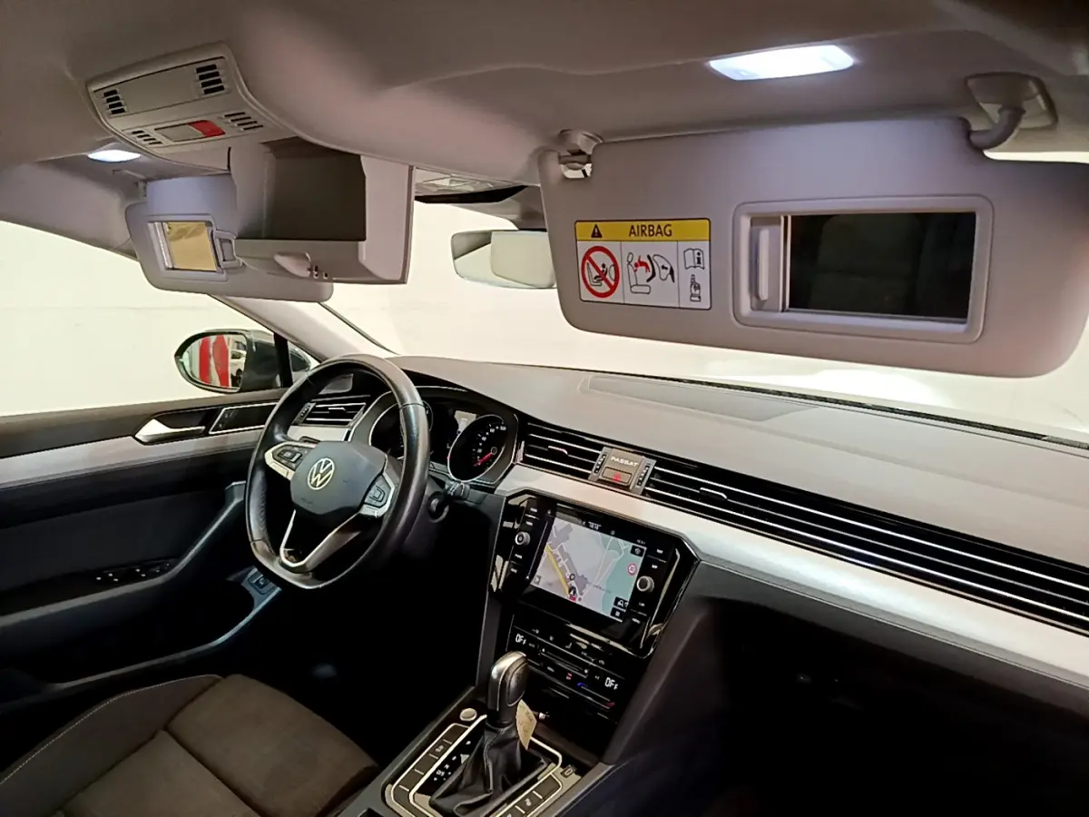 Intérieur avant droit de la Volkswagen Passat gris foncé 2021, avec tableau de bord moderne et écran tactile central.