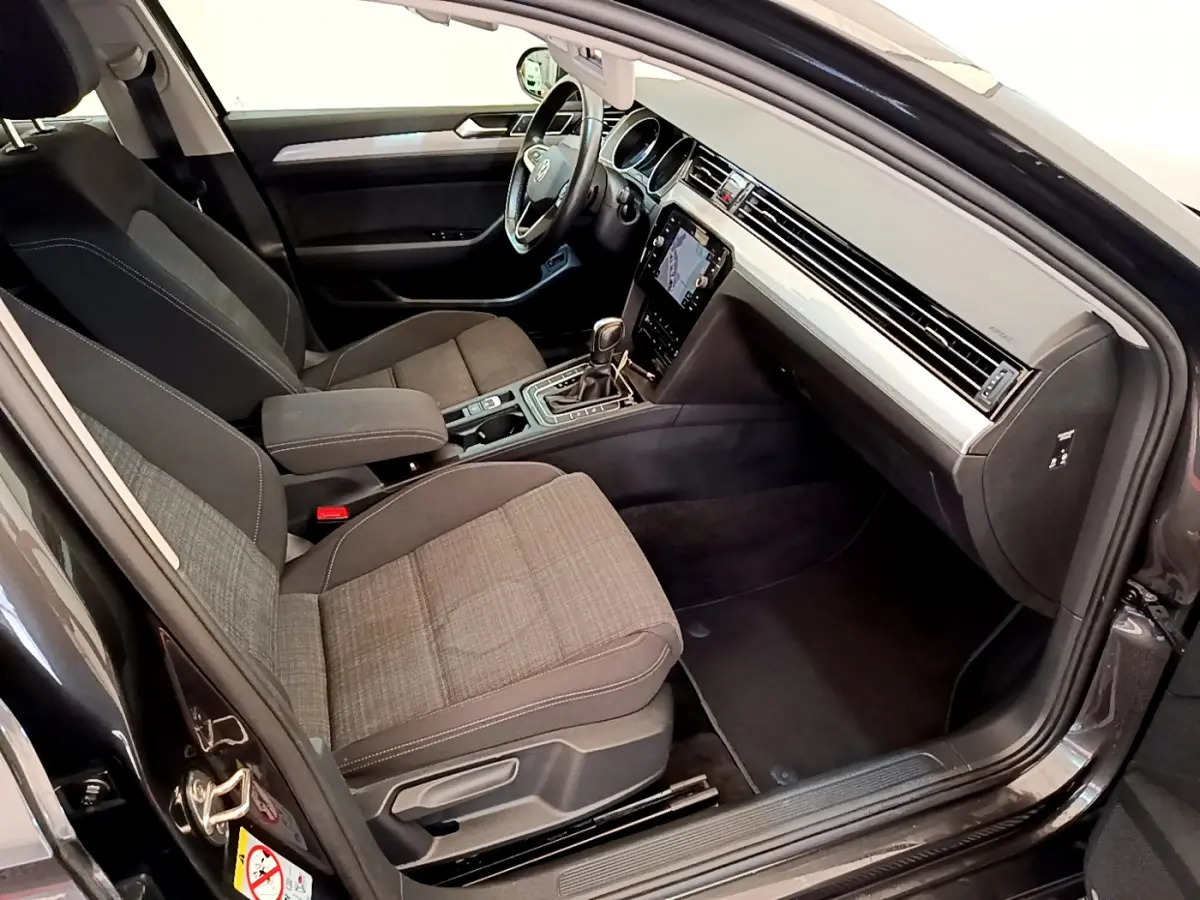 Intérieur avant droit d'une Volkswagen Passat gris foncé 2021 avec sièges tissu et écran tactile central.