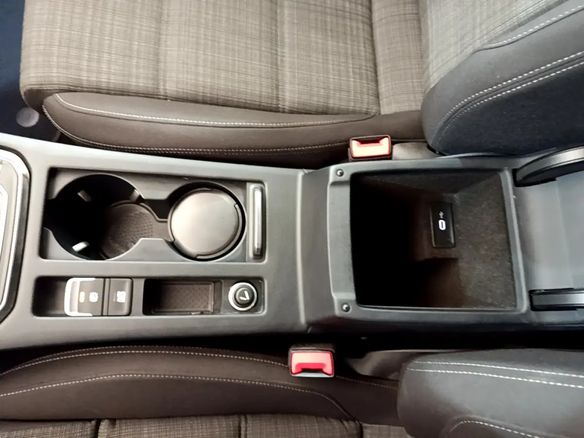Vue plongeante sur la console centrale et les sièges avant en tissu gris de la Volkswagen Passat 2.0 TDI 2021.