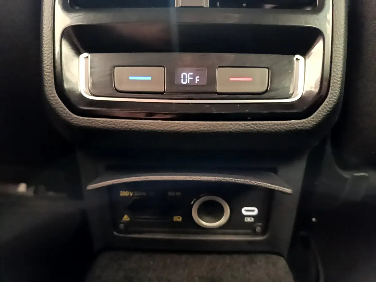 Vue rapprochée du panneau de commande de climatisation arrière et prises USB et 12V dans une Volkswagen Passat gris foncé 2021.