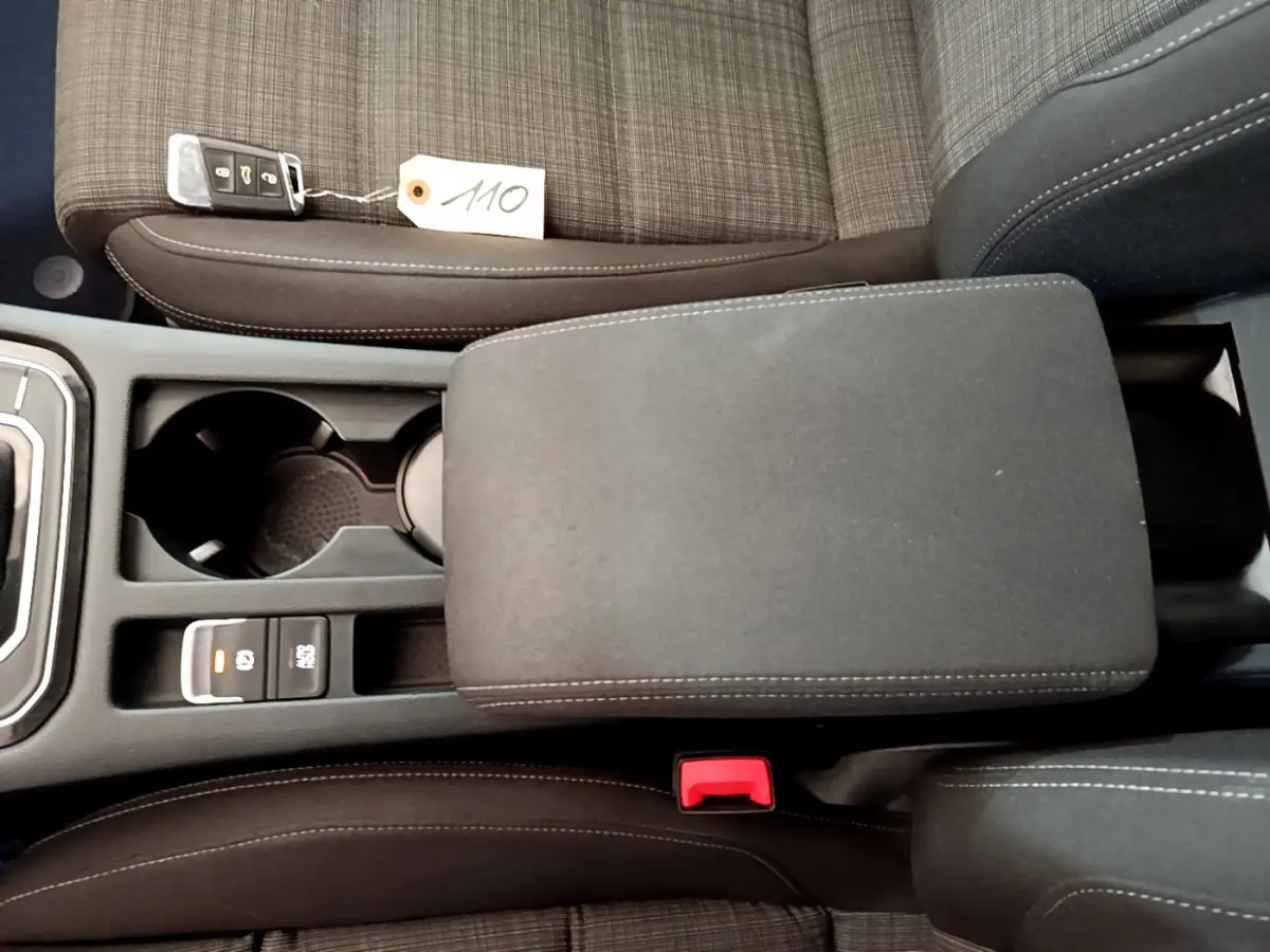 Vue plongeante sur la console centrale et sièges gris foncé à motifs de la Volkswagen Passat 2.0 TDI 2021 avec clé posée.