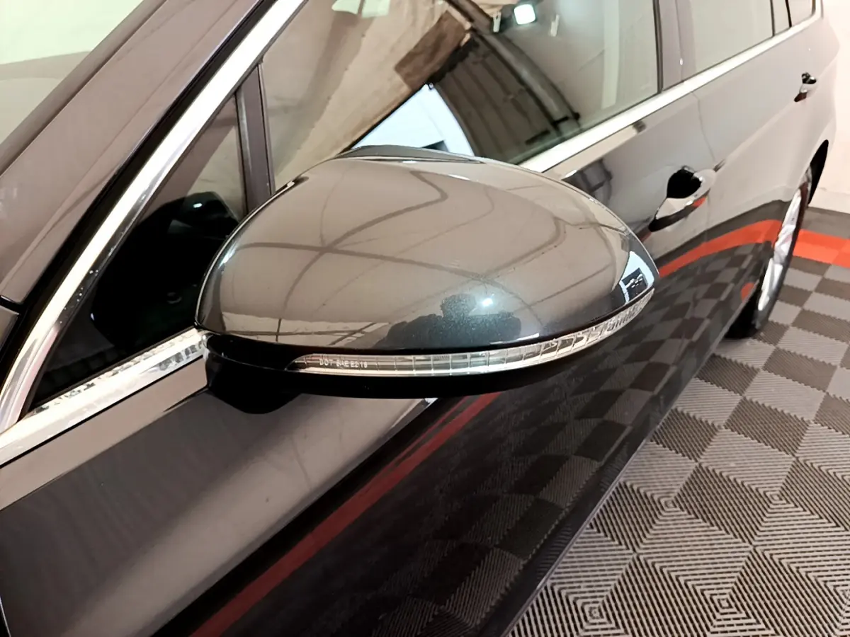 Rétroviseur droit gris foncé de la Volkswagen Passat 2021, avec clignotant intégré, vue rapprochée côté passager.