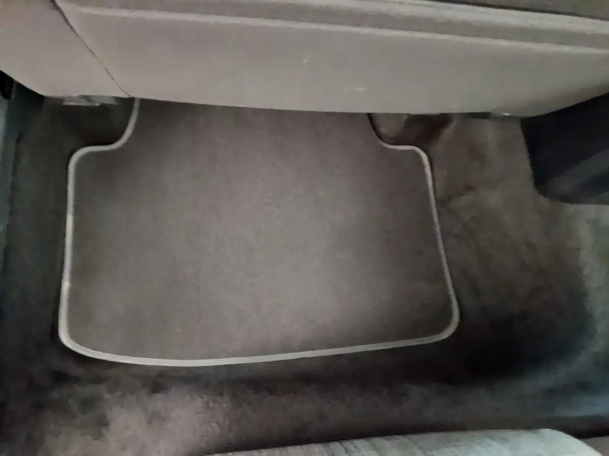 Tapis de sol gris foncé sous le siège avant droit d'une Volkswagen Passat 2.0 TDI 2021, intérieur sobre.