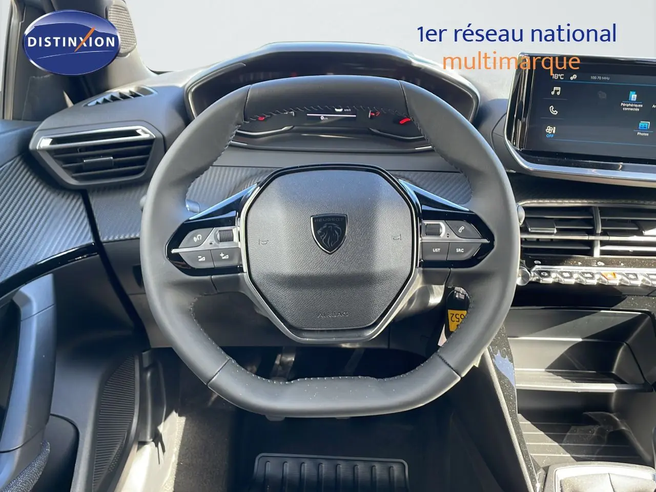 Vue rapprochée du volant multifonction noir et du tableau de bord moderne d'une Peugeot 2008 blanche.