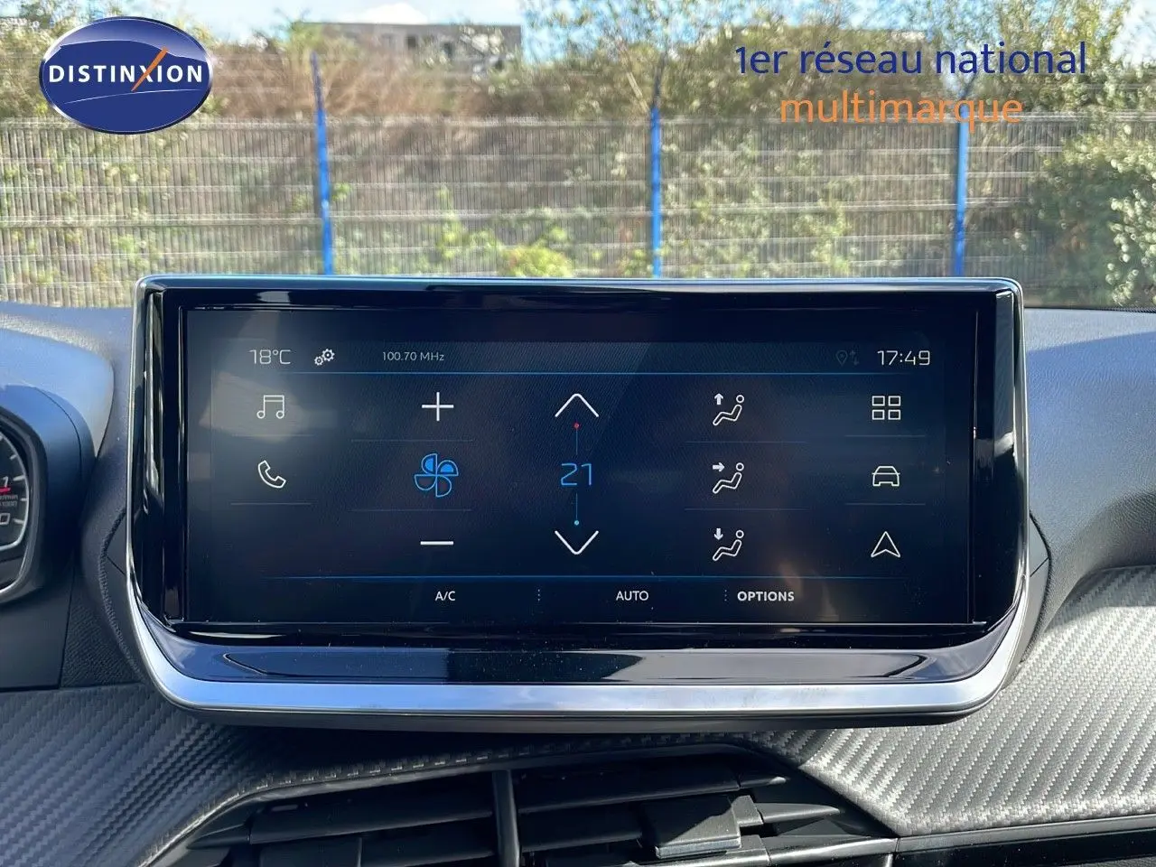 Écran tactile central affichant la climatisation à 21°C dans le tableau de bord d'une Peugeot 2008 blanche.