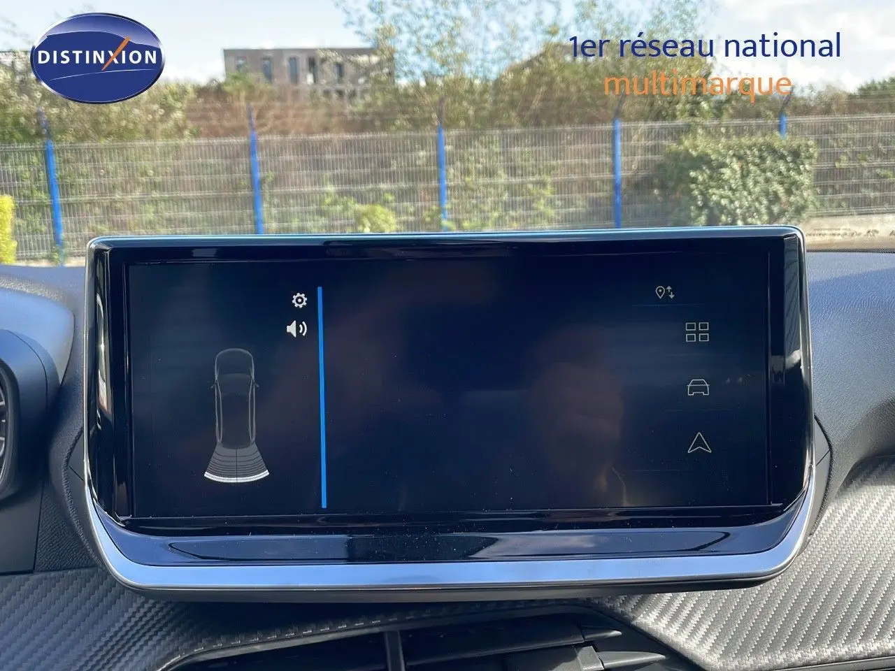 Écran tactile central du tableau de bord du Peugeot 2008 blanc, affichant les capteurs de stationnement arrière.