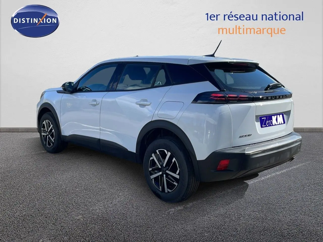 Peugeot 2008 blanc Okenite métal en vue 3/4 arrière droit, avec toit noir et feux arrière LED distinctifs.