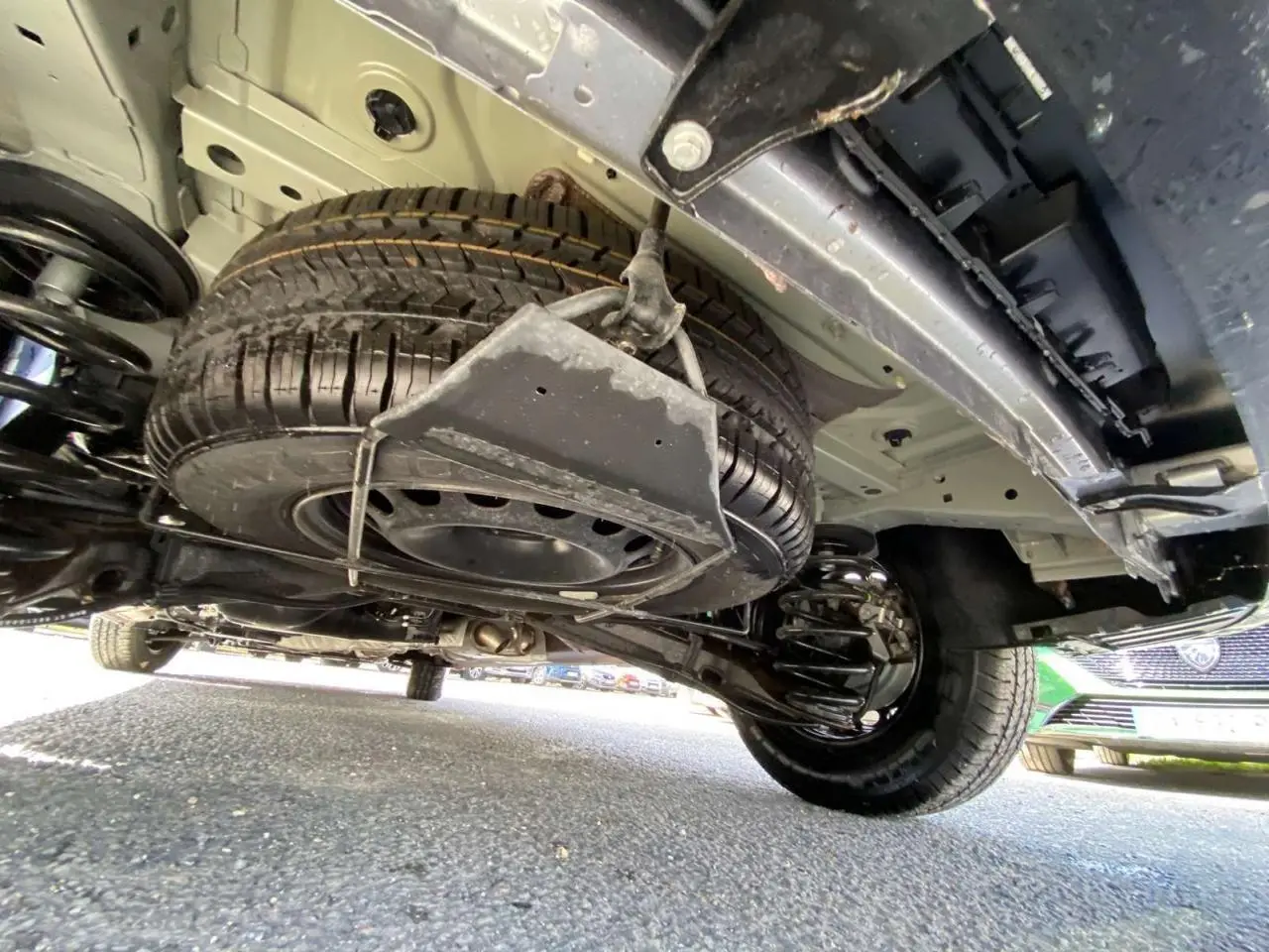 Vue sous le Peugeot Expert Fourgon gris Artense métal montrant la roue de secours et la suspension arrière.