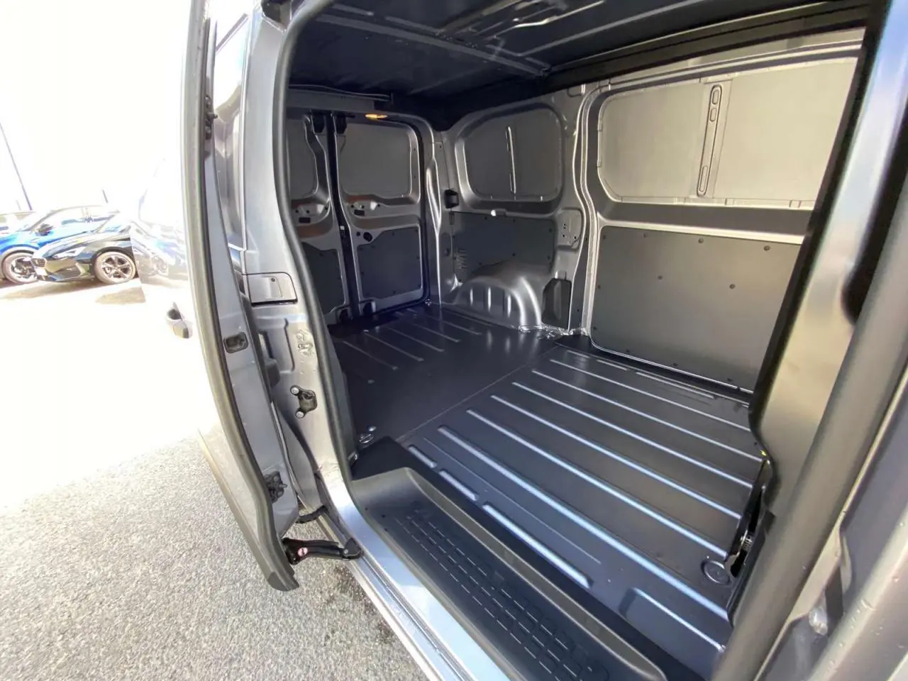 Vue intérieure du coffre arrière ouvert du Peugeot Expert Fourgon gris Artense Métal, montrant l'espace de chargement métallique.