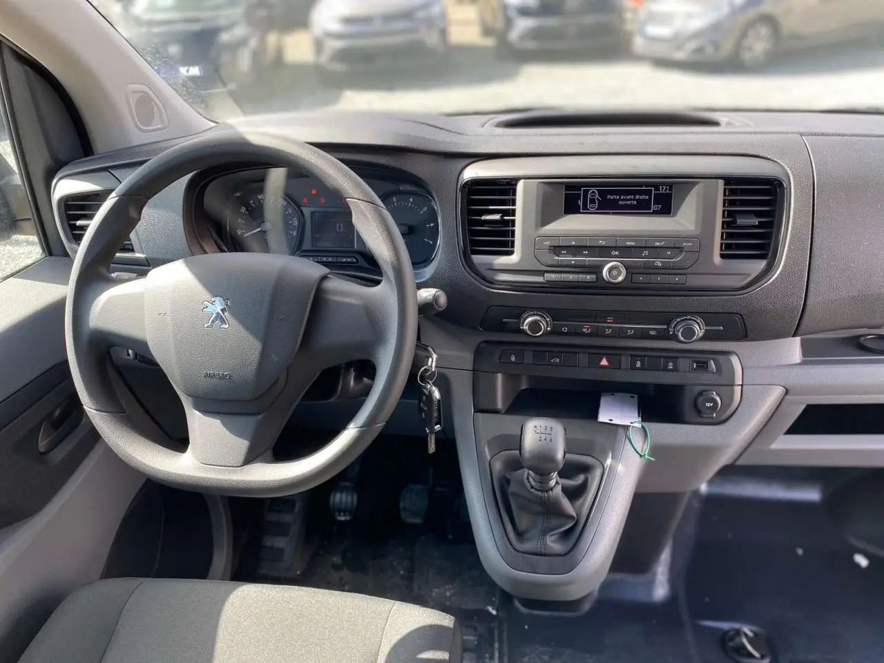 Vue intérieure du tableau de bord du Peugeot Expert Fourgon 2022, volant et levier de vitesses manuelle visibles.