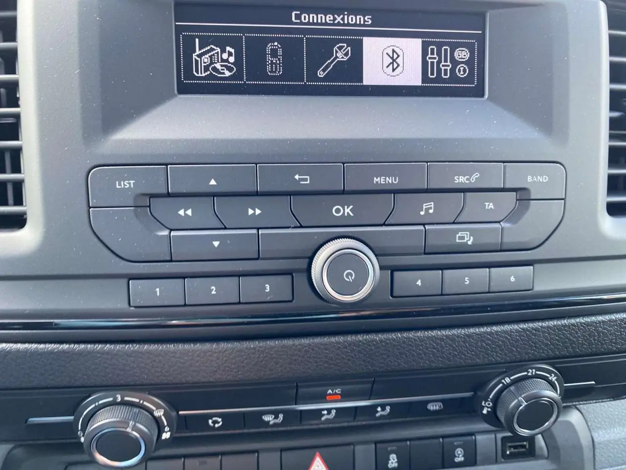 Tableau de bord du Peugeot Expert Fourgon gris Artense, vue centrée sur la console avec commandes audio et climatisation.
