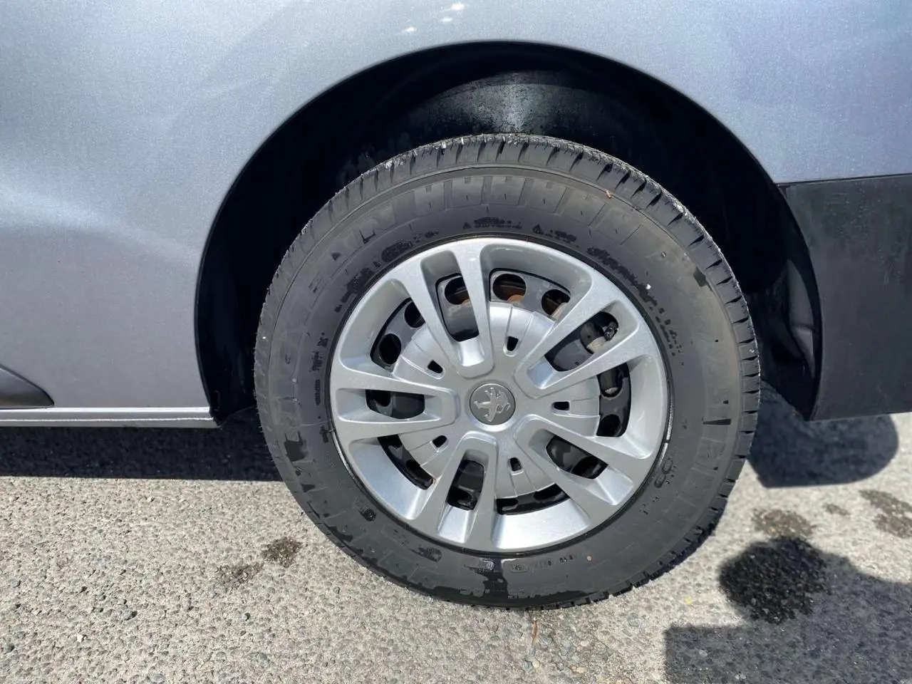 Gros plan sur la roue avant droite du Peugeot Expert Fourgon gris Artense métallisé avec enjoliveur d'origine.