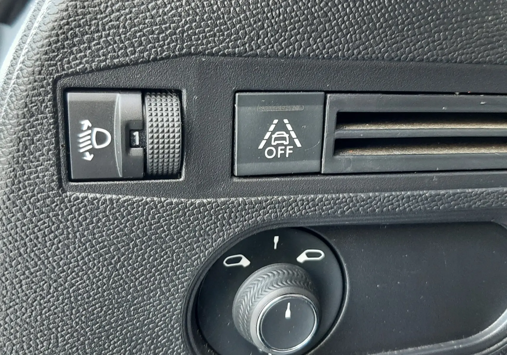 Gros plan sur les commandes noires du tableau de bord côté gauche du DS3 Crossback blanc perle avec toit noir.