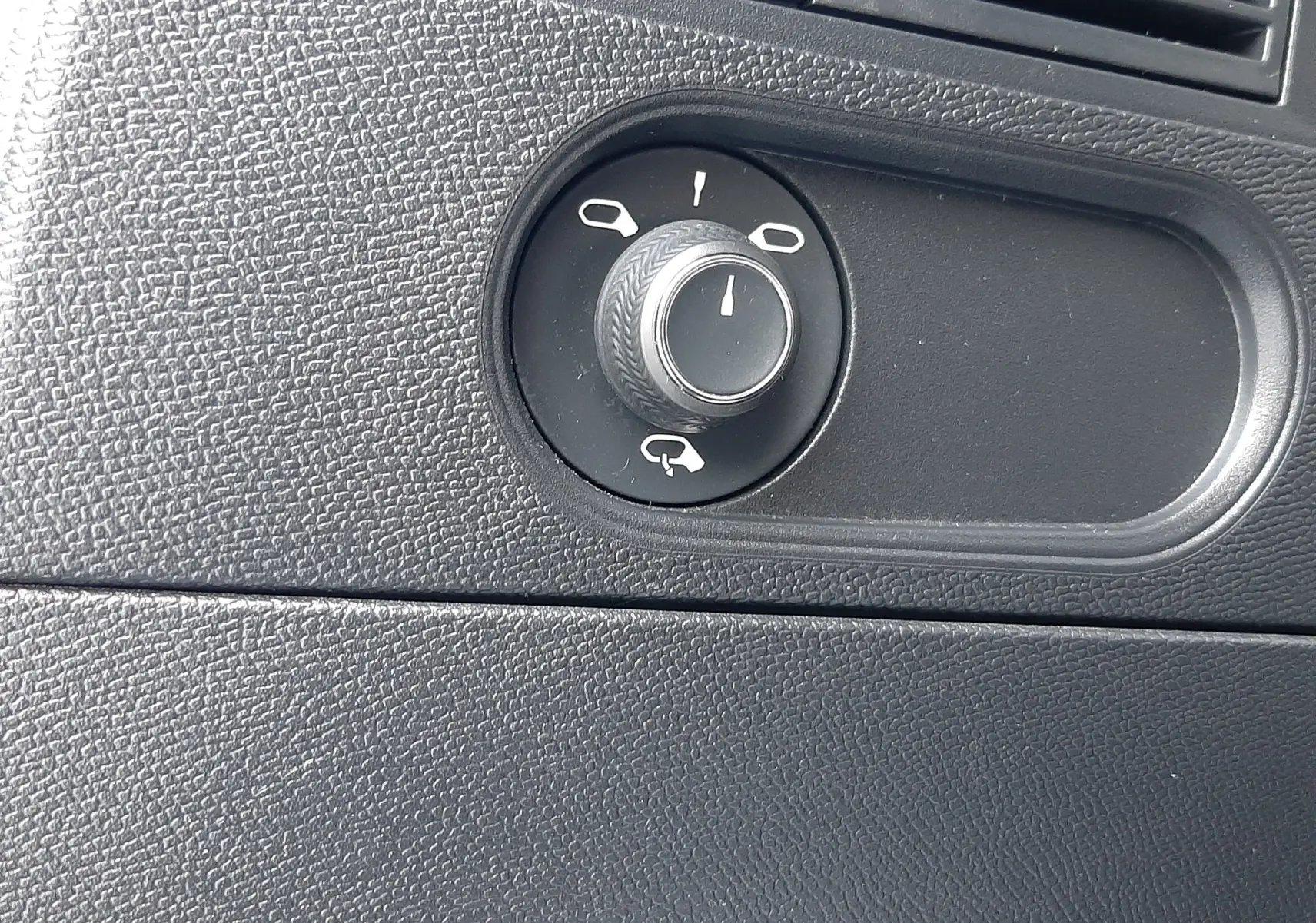 Gros plan sur le bouton de réglage des rétroviseurs dans l'habitacle noir du DS3 Crossback blanc perle toit noir.