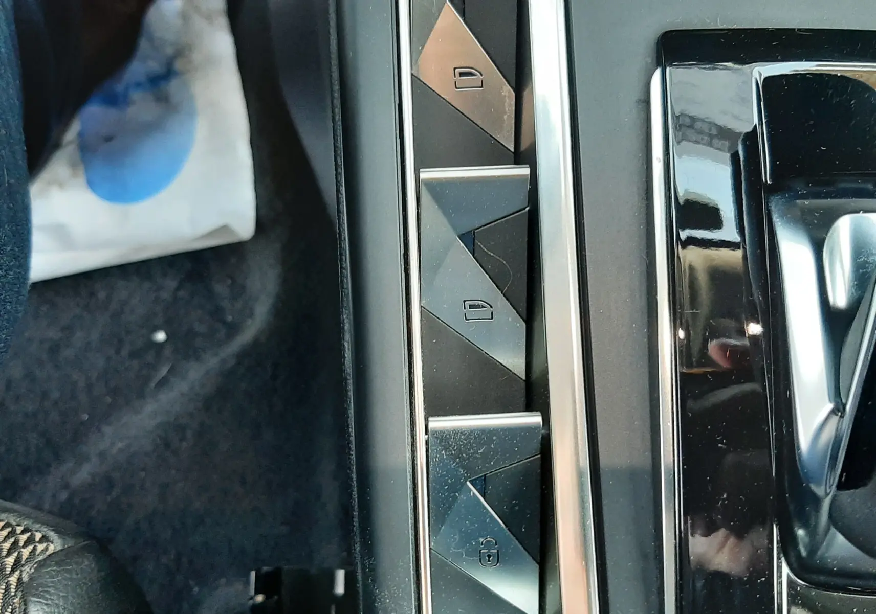 Gros plan sur les boutons de verrouillage centralisé dans l'habitacle noir du DS3 Crossback blanc perle toit noir.