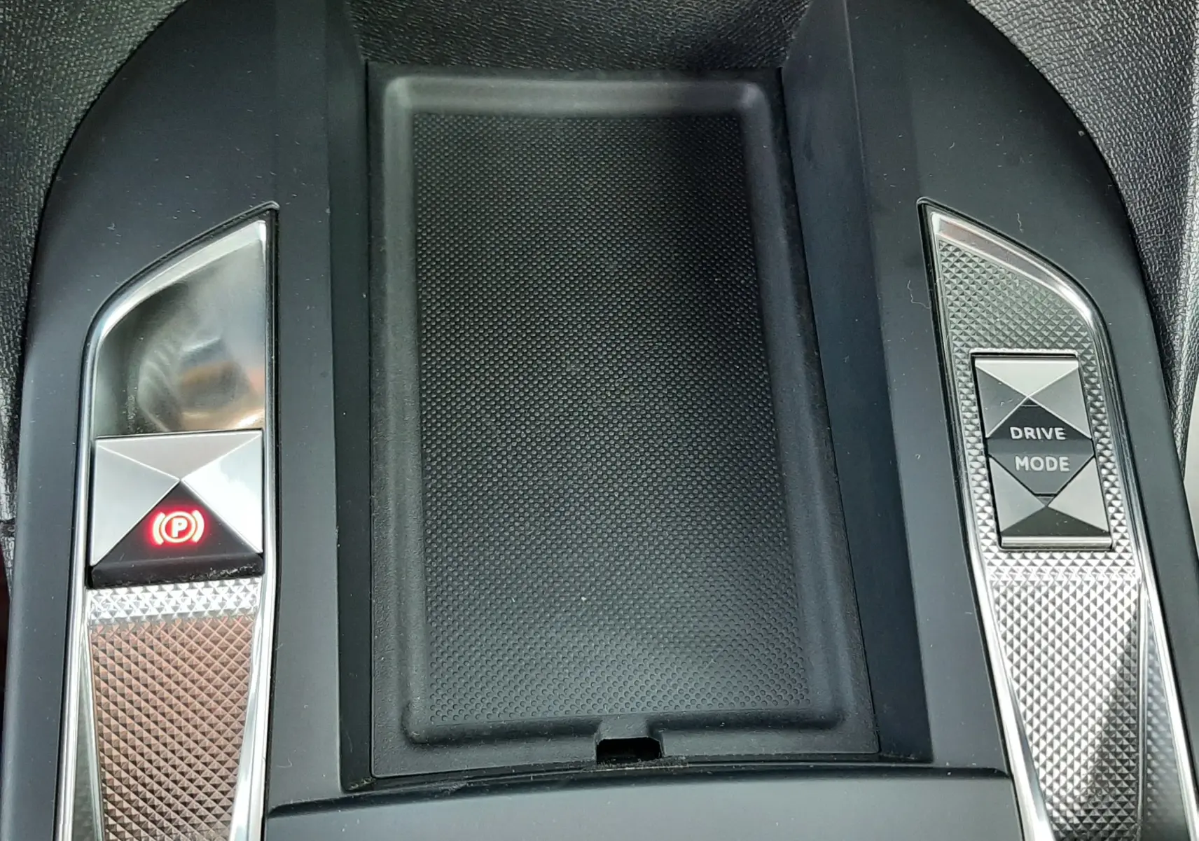 Vue rapprochée de la console centrale noire du DS3 Crossback 2019 avec boutons frein à main et mode de conduite.