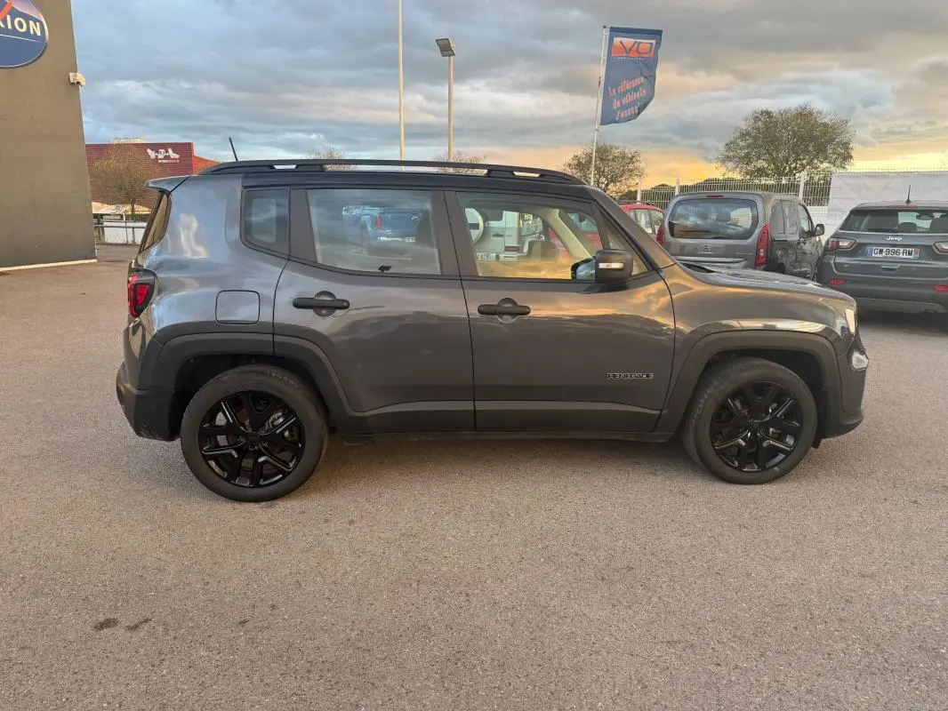Vue de profil côté gauche d'un Jeep Renegade gris anthracite 2024 avec jantes alliage noires et barres de toit.
