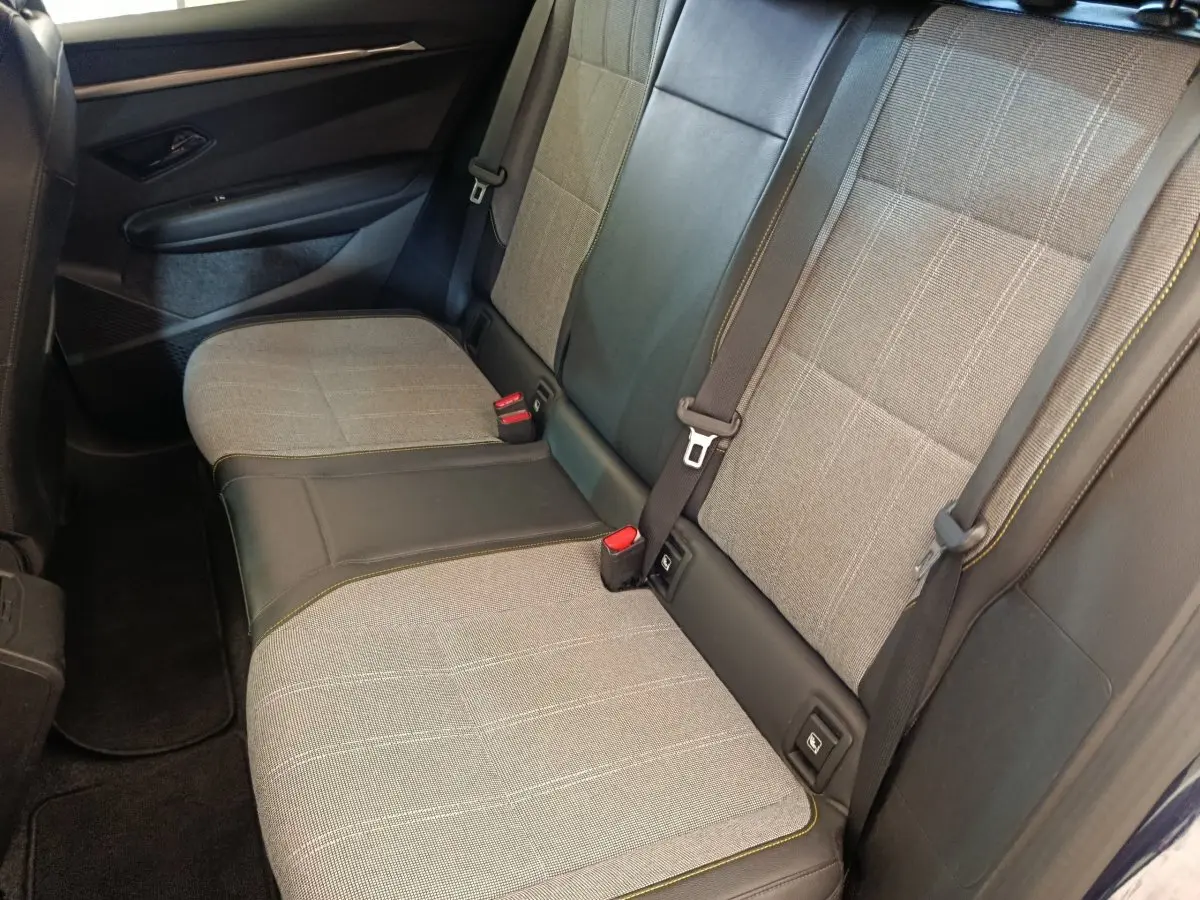 Vue latérale intérieure montrant la banquette arrière grise et noire avec ceintures et détails de la Renault Megane 2023.