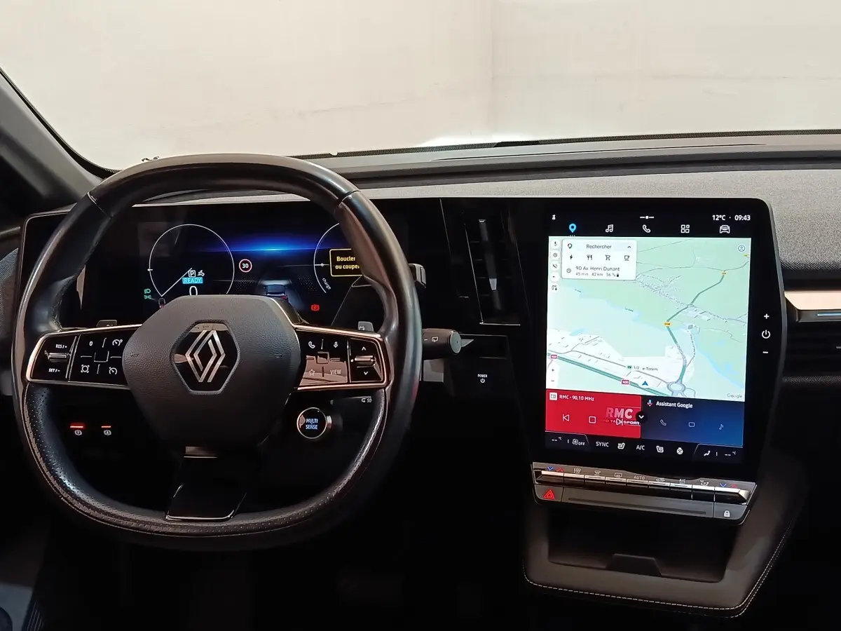Intérieur Renault Megane Techno EV60 2023, vue du tableau de bord avec volant cuir et grand écran tactile central.