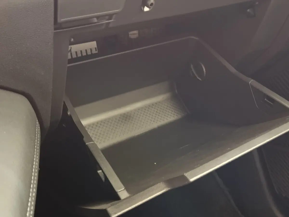 Gant de rangement ouvert côté passager dans l’habitacle sombre d’une Renault Mégane électrique 2023.