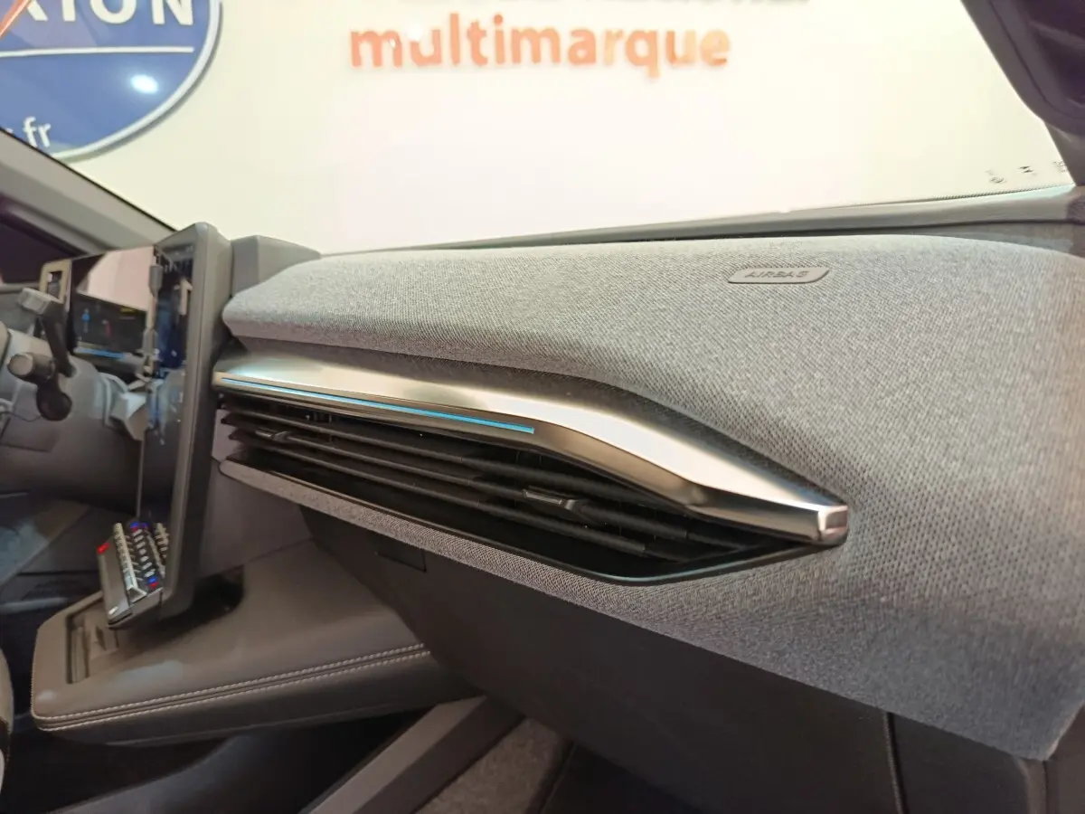 Détail intérieur du tableau de bord gris clair avec aérateurs et écran tactile de la Renault Mégane Techno EV60 2023.