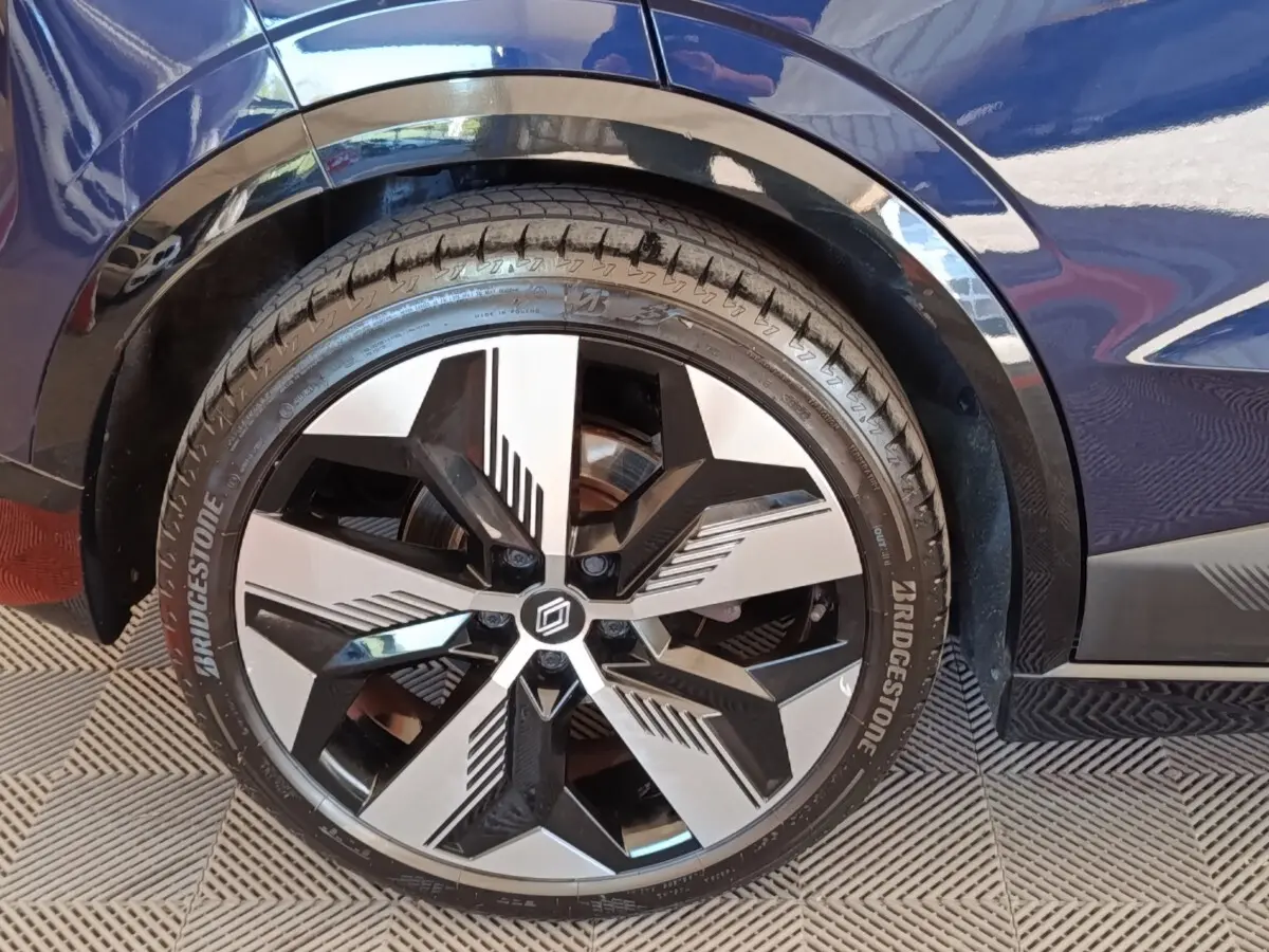 Gros plan sur la roue avant droite de la Renault Mégane Techno EV60 bleu, avec jante diamantée au design moderne.